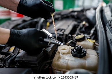 Optical instrument for testing antifreeze, windshield washer fluid and electrolyte density. Mechanic uses car refractometer in service - Powered by Shutterstock