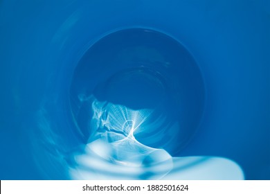 Optical refraction of light from the sun's rays on the surface of blue paint. Blurred image of a circular spot on the left with a gradient. Soft selective focus. Graphic image, abstract background.