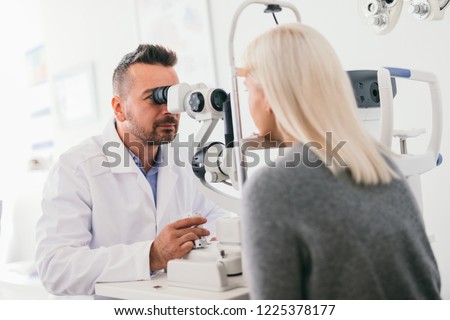 Optician checking his patient's eyes. Medical examination, proffesional optic machine.