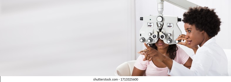 Optician Doing Optometry Eye Exam For Black African Patient