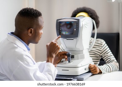 Optician Doing Optometry Eye Exam Of Black African American Teen Girl In Modern Clinic. Doctor And Patient In Ophthalmology Clinic.