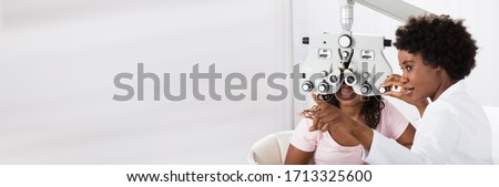 Optician Doing Optometry Eye Exam For Black African Patient