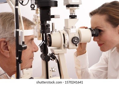 Optician performing eye exam on man స్టాక్ ఫోటో