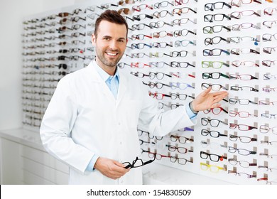 Optician selling glasses. Eye doctor, optometris at work.