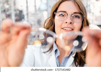 Optician Showing And Suggesting Eyeglasses In Optical Shop