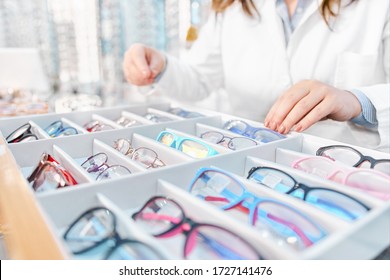 Optician Suggesting And Showing Eyeglasses In An Optical Shop