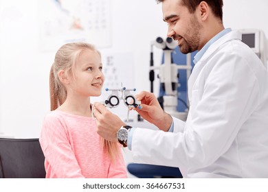 Optician With Trial Frame And Girl At Clinic