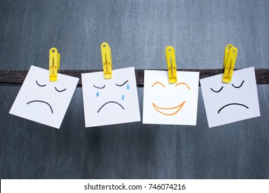 Optimist between pessimists, different emotions drawn on notes, dark background.  - Shutterstock ID 746074216