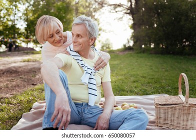 Optimistic aging couple sharing positivity at the picnic