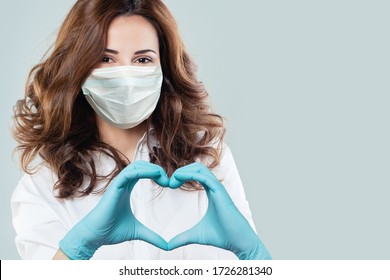 Optimistic Doctor Woman In Protective Mask Making Heart. Healthcare, Medicine And Treatment Concept