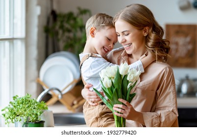 Optimistic Family: Mother With Bouquet Of  Tulips Laughing And Touching Forehead With Happy Son  During Holiday Celebration  Mothers Day At Home