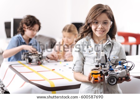 Optimistic girl demonstrating tech project at school