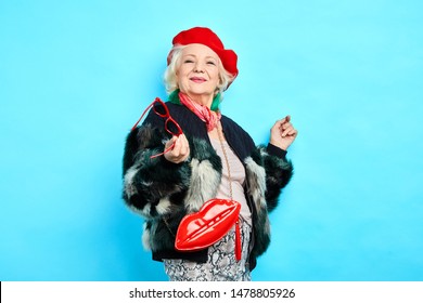 Optimistic Old Woman Doesn't Think About Her Age, Oldness. Close Up Photo, Isolated Blue Background. Lifestyle, Leisure. Happiness