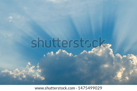 Optimistic sunset rays behind the clouds. Glow in the sky. Symbol of light. Beautiful scene of nature.