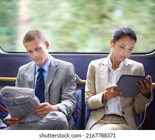 Optimizing their travel time wisely. Two business people reading catching up on the news on their commute to work. - Powered by Shutterstock