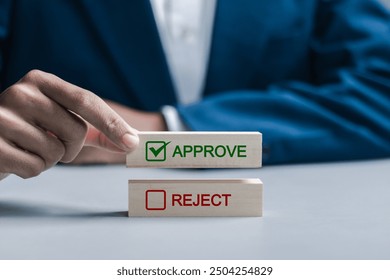 Option to approve or reject on wooden blocks. Businessman select wooden block with text Approve for document approval , project assessment evaluation acceptance, and quality assurance.