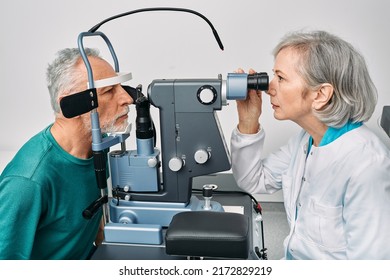 Optometrist doing sight test for senior man at modern ophthalmology clinic. Eye exam and vision diagnostic - Powered by Shutterstock