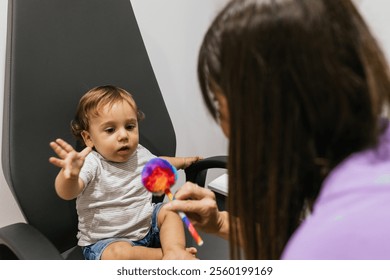 Optometrist examining infant's vision with colorful toy - Powered by Shutterstock