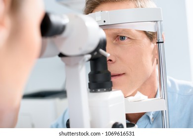 Optometrist Examining Man With Modern Optical Equipment