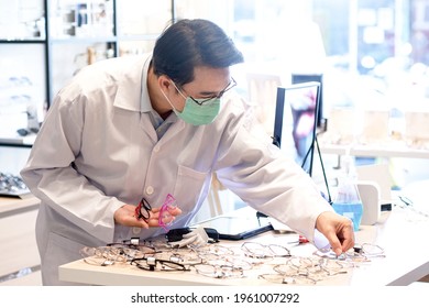 Optometrist Or Optician Wearing Medical Mask Checking Glasses In Optician Shop, Glasses For Sale 