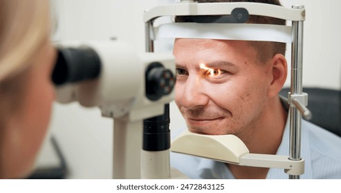 Optometrist, patient and assessment in clinic for eye exam, optometry and vision with ophthalmoscope. Specialist, man and machine in hospital for wellness, healthcare or ophthalmology for glaucoma - Powered by Shutterstock