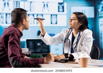 Optometrist performing a vision test in a modern clinical office. Indian patient undergoing an eye exam, optician using diagnostic tools for eyesight correction and treatment in a consultation. - Powered by Shutterstock