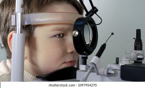 Optometrist Performing Visual Field Test Of Young Boy