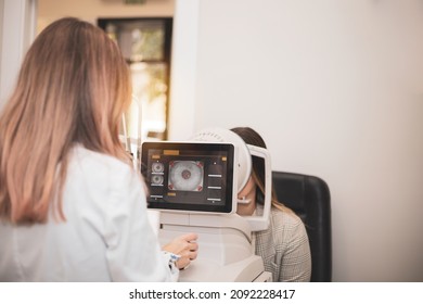 an optometrist uses a wide cone corneal topographer to take information from a patient's cornea.