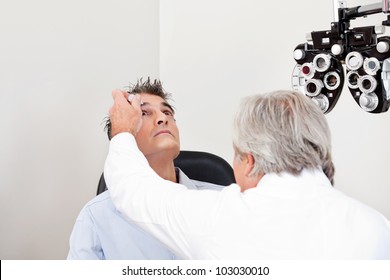 Optometrist using mydriatics eye drops to numb the eyes of his patient for further tests - Powered by Shutterstock