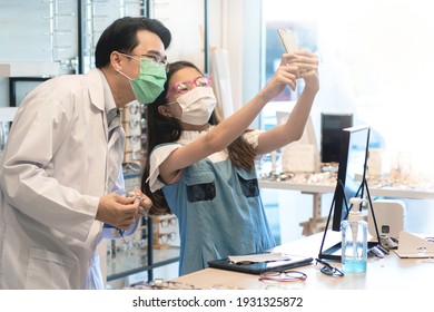 Optometry And Child Girl Wearing Medical Mask Taking Selfie With New Glasses Together While Shopping Together At The Eyewear Store