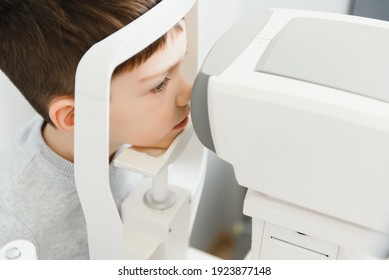 Optometry Concept. Female Optometrist Optician Doctor Examines Eyesight Of Child Boy In Eye Ophthalmological Clinic