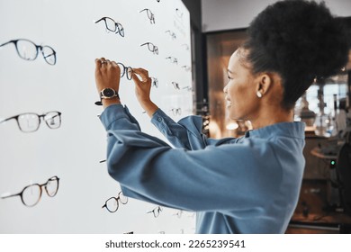 Optometry, healthcare and woman choosing a frame for her prescription lenses at optical store. Medical, ophthalmology and African female patient shopping for new glasses or spectacles at optic clinic - Powered by Shutterstock