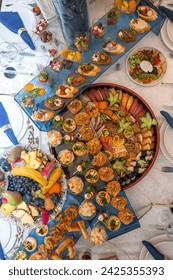 An opulent buffet showcasing a lavish assortment of fresh seafood, sushi, salads, fruits, and pastries, beautifully arranged on a pristine white tablecloth for a luxurious and celebratory event.