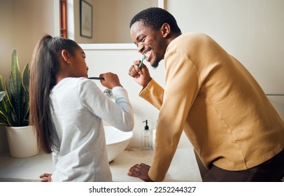 Oral care, brushing teeth and father with daughter in bathroom for hygiene, grooming and bonding. Dental health, girl and black people cleaning while having fun, playful and smile in their home - Powered by Shutterstock