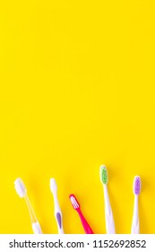 Oral Hygeine. Toothbrushes On Yellow Background Top View Copy Space