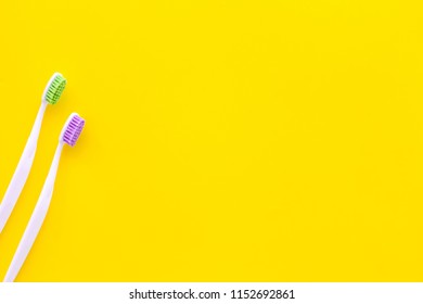 Oral Hygeine. Toothbrushes On Yellow Background Top View Copy Space