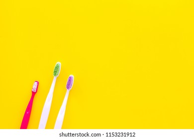 Oral Hygeine. Toothbrushes On Yellow Background Top View Copy Space