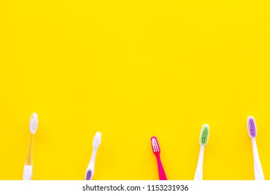 Oral Hygeine. Toothbrushes On Yellow Background Top View Copy Space