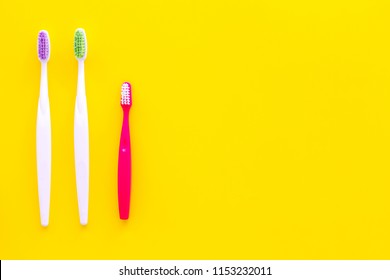 Oral Hygeine. Toothbrushes On Yellow Background Top View Copy Space