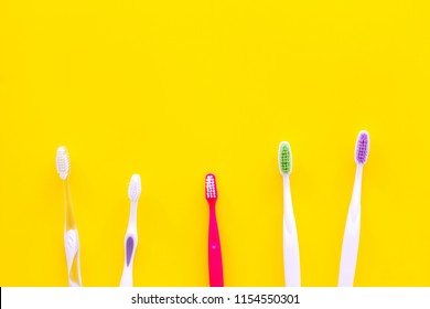 Oral Hygeine. Toothbrushes On Yellow Background Top View Copy Space