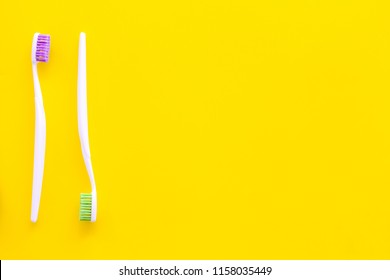 Oral Hygeine. Toothbrushes On Yellow Background Top View Copy Space