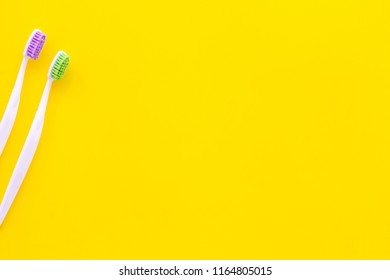 Oral Hygeine. Toothbrushes On Yellow Background Top View Copy Space