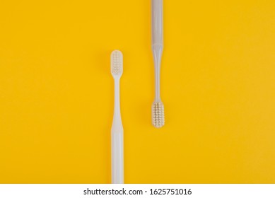 Oral Hygeine. Toothbrushes On Yellow Background Top View Copy Space