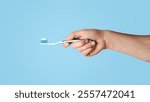 Oral hygiene concept. Young guy holding toothbrush with paste on light grey background, closeup. Panorama