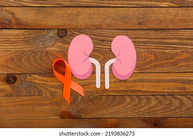 Orange Awareness Ribbon And Paper Kidneys On Wooden Background