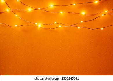 Orange Background With Illuminated Lights Of Garland