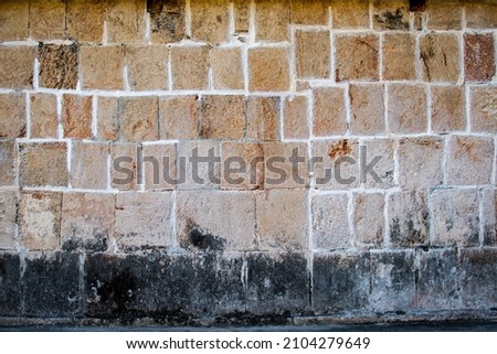 Orange background with a rustic stones. irregular Rectangles, frame of rough texture. Wall. Very old house 
