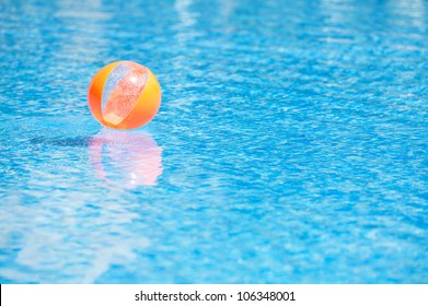 Orange Ball In The Blue Water Swimming Pool