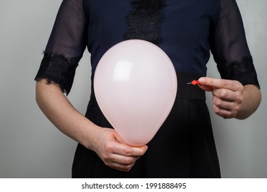 Orange Balloon And Needle In A Woman's Hand. Bloated Stomach.