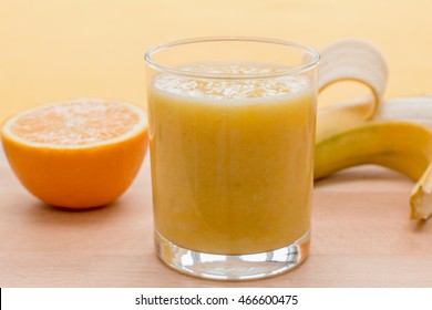 Orange And Banana Smoothie In A Glass On An Orange Background